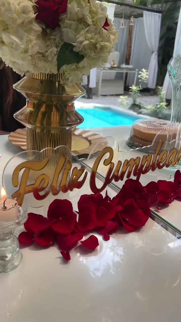 Letrero de feliz cumpleaños con pétalos de rosa en una mesa de Celestial