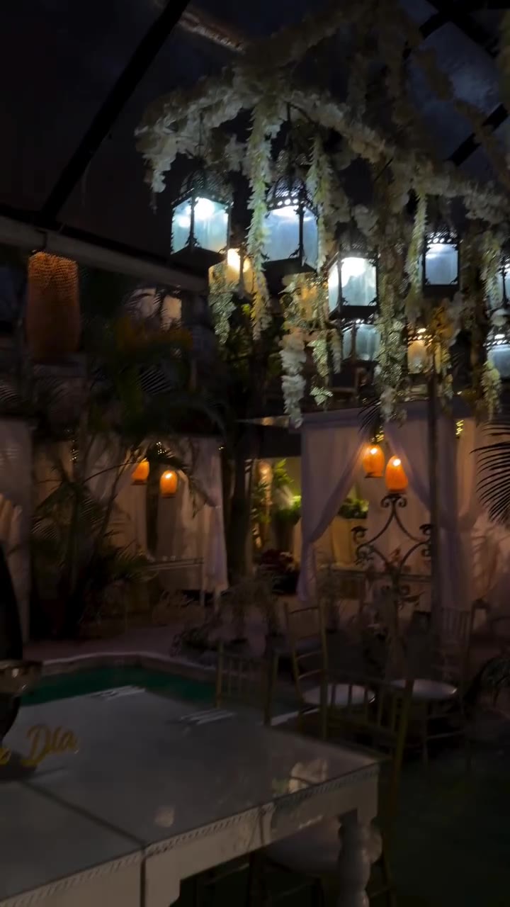 La terraza de Celestial de noche, con faroles entre las flores