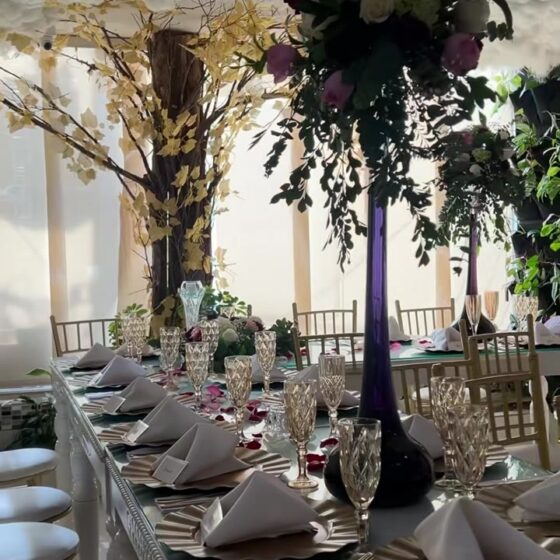 Mesa larga montada para una boda bajo el techo de nubes