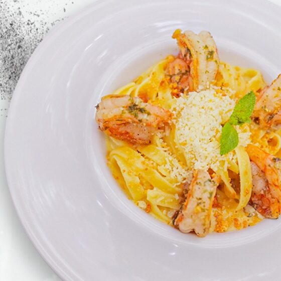 Pasta con langostinos y camarón en salsa napolitana con parmesano